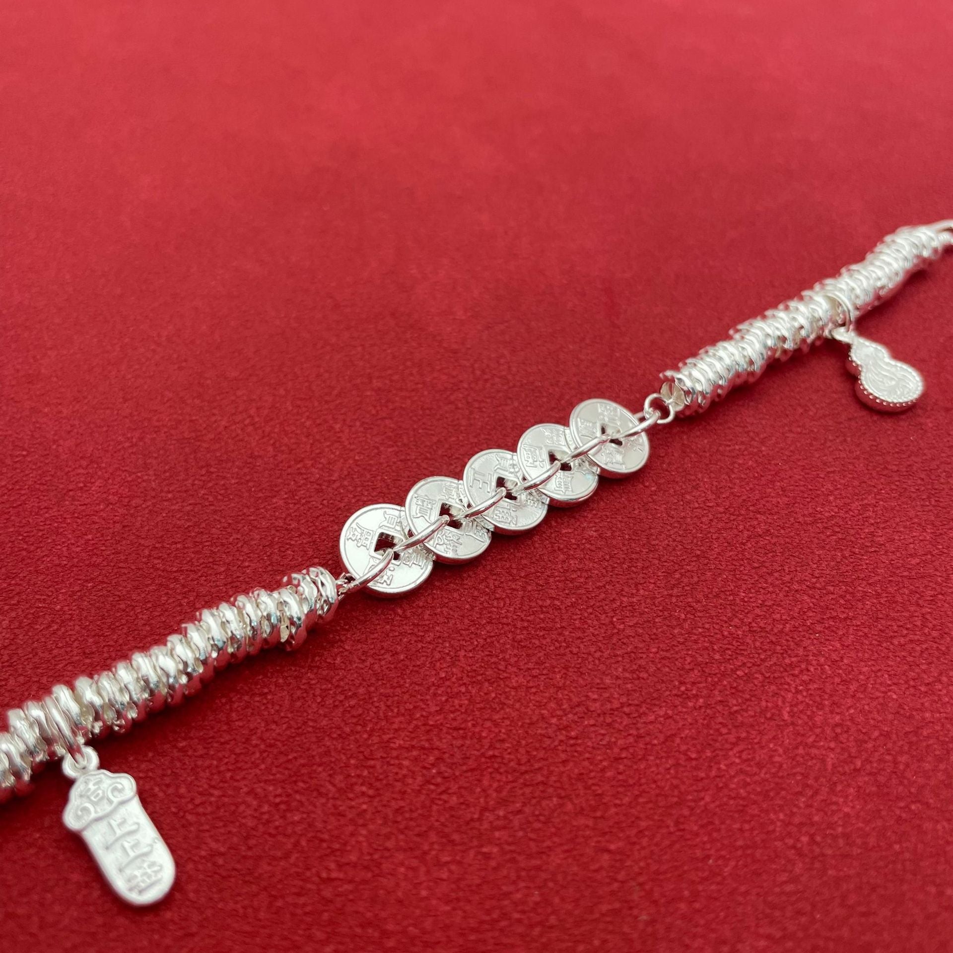 Sterling silver bracelet with five emperor coins, a traditional Chinese style, symbolizing good fortune, peace, joy, versatility, elegance, and Chinese aesthetics.