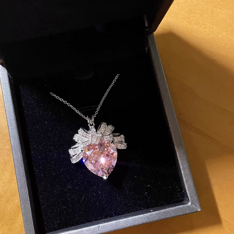 The Lycoris Radiata-inspired children's play series versatile clavicle chain with bow and silk pendant, featuring a heart-shaped zircon and pink diamond design.