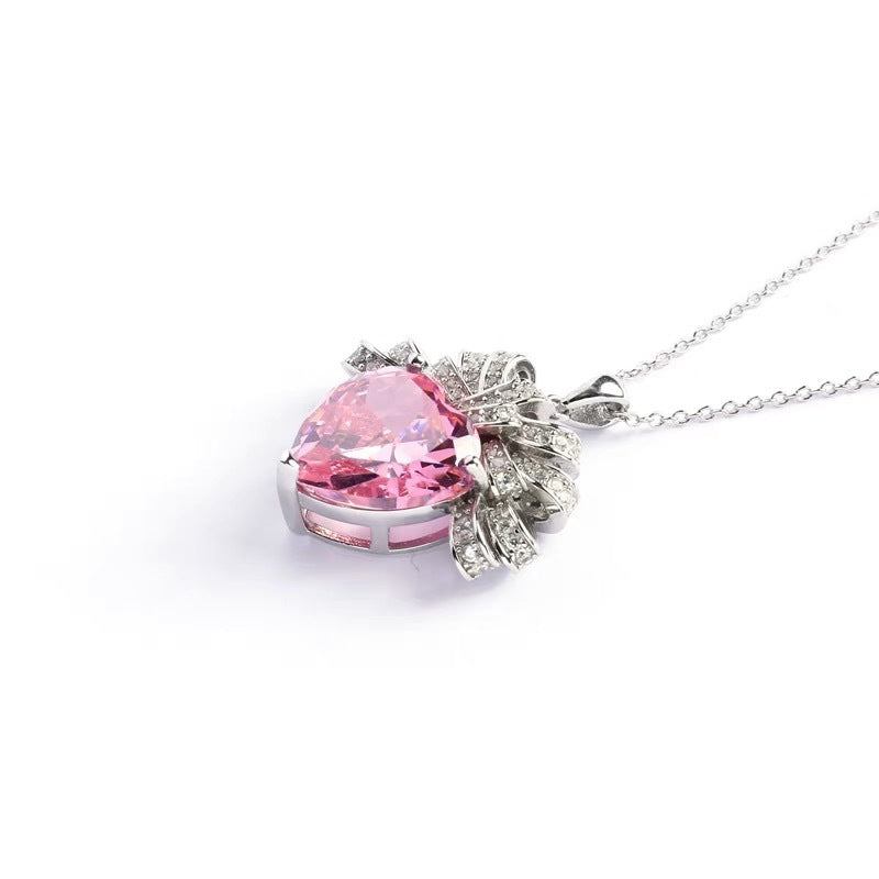 The Lycoris Radiata-inspired children's play series versatile clavicle chain with bow and silk pendant, featuring a heart-shaped zircon and pink diamond design.