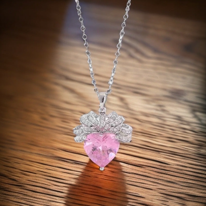 The Lycoris Radiata-inspired children's play series versatile clavicle chain with bow and silk pendant, featuring a heart-shaped zircon and pink diamond design.