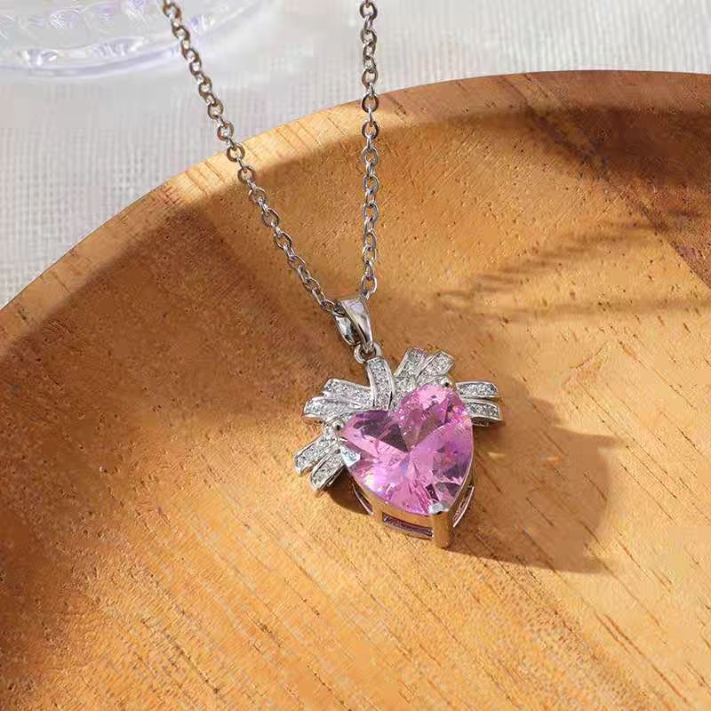 The Lycoris Radiata-inspired children's play series versatile clavicle chain with bow and silk pendant, featuring a heart-shaped zircon and pink diamond design.